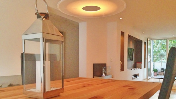 Una mesa de madera con un farol colgante, una chimenea y vistas al exterior.