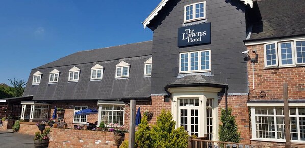 The Lawns Hotel with a brick facade, multiple windows, and a signboard. - The Lawns Hotel (Derby)