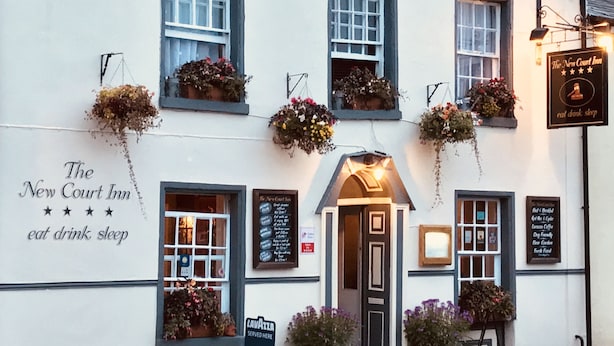 The New Court Inn with a signboard advertising "eat drink sleep" and a sign for "Lavazza served here". - The New Court Inn (Usk)