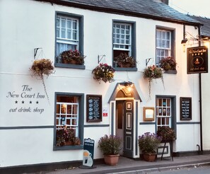 The New Court Inn with a signboard advertising "eat drink sleep" and a sign for "Lavazza served here". - The New Court Inn (Usk)
