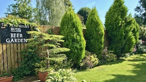 A garden with a sign for The New Court Hotel Beer Garden. - The New Court Inn (Usk)