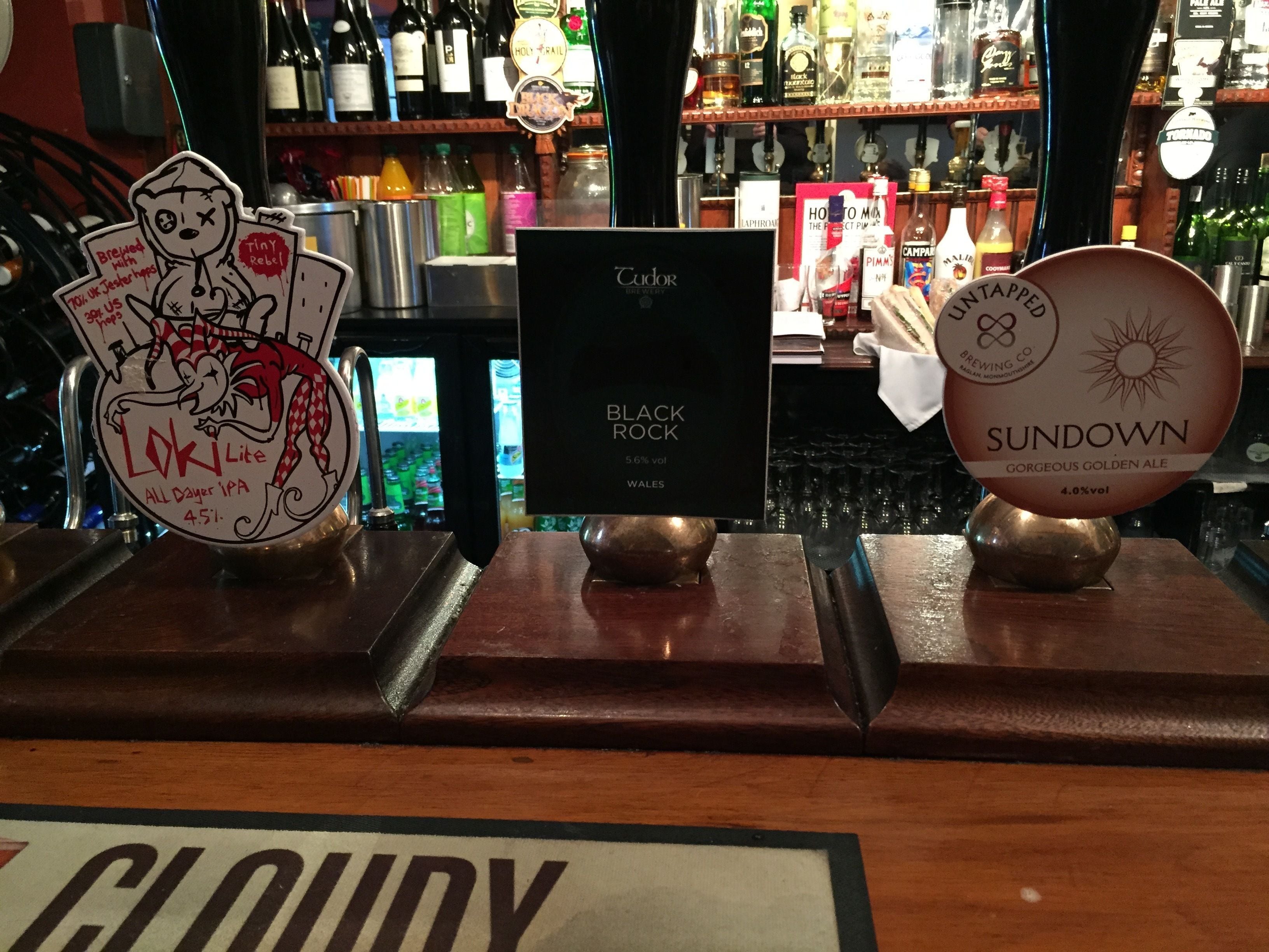 A bar with a variety of beer taps, including Black Rock and Sundown.