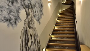 Eine Treppe mit Holzdielen und einem Wandbild eines Baumes.
