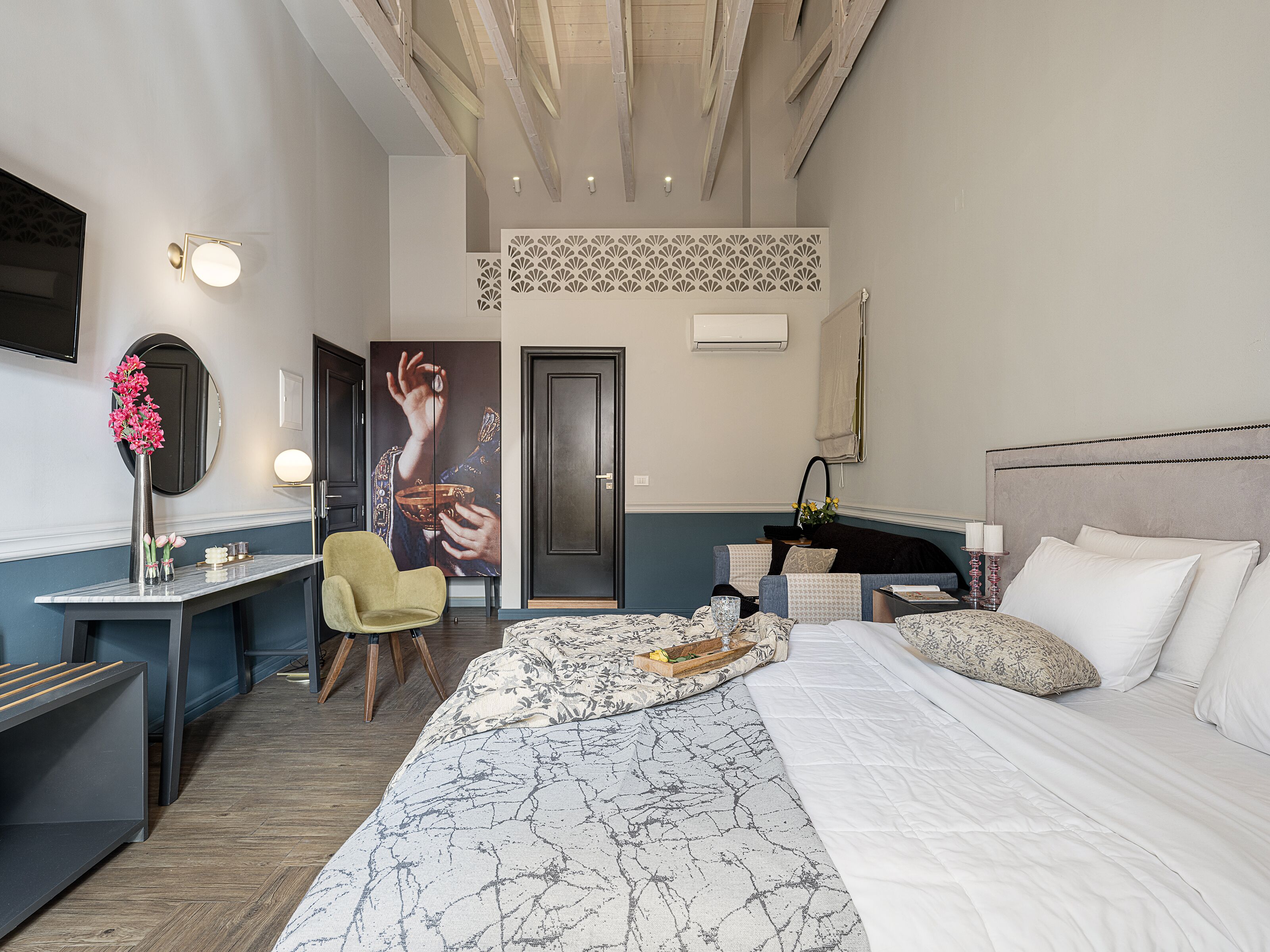 A modern hotel room with a large bed, a desk, and a chair.