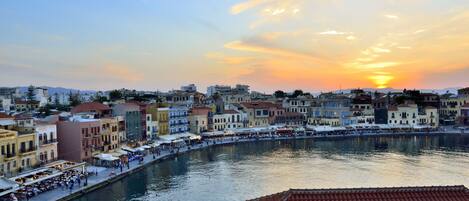 Una passeggiata sul lungomare con edifici, un canale e un tramonto.