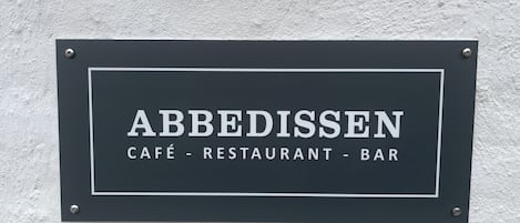 A signboard with the name "ABBEDISSEN" and the words "CAFÉ - RESTAURANT - BAR" indicating the establishment type.