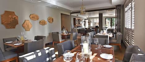 A dining area with a long table set for a meal, surrounded by chairs.