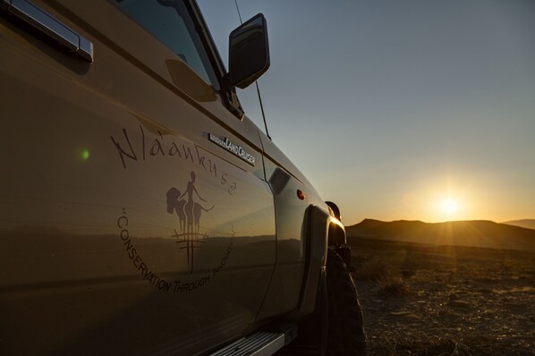 A Toyota Land Cruiser with a side decal featuring a woman and child, and the text "Nala's Conservation Through Innovation".