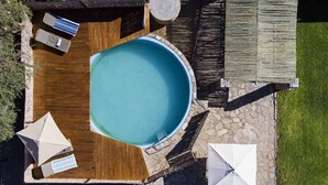 An aerial view of a swimming pool with wooden deck, lounge chairs, and umbrellas. - Neuras Wine & Wildlife Estate (Sesriem)