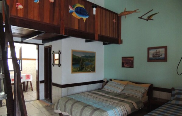 A bedroom with a bed, a wooden ceiling, and a painting on the wall.