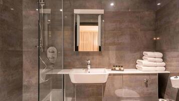 Une salle de bain moderne avec une douche à parois de verre, un meuble-lavabo et des toilettes.