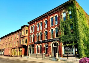 A historic brick building with a storefront for Robert H. Newell & Co. and a hotel sign. - Hart House Hotel (Medina)