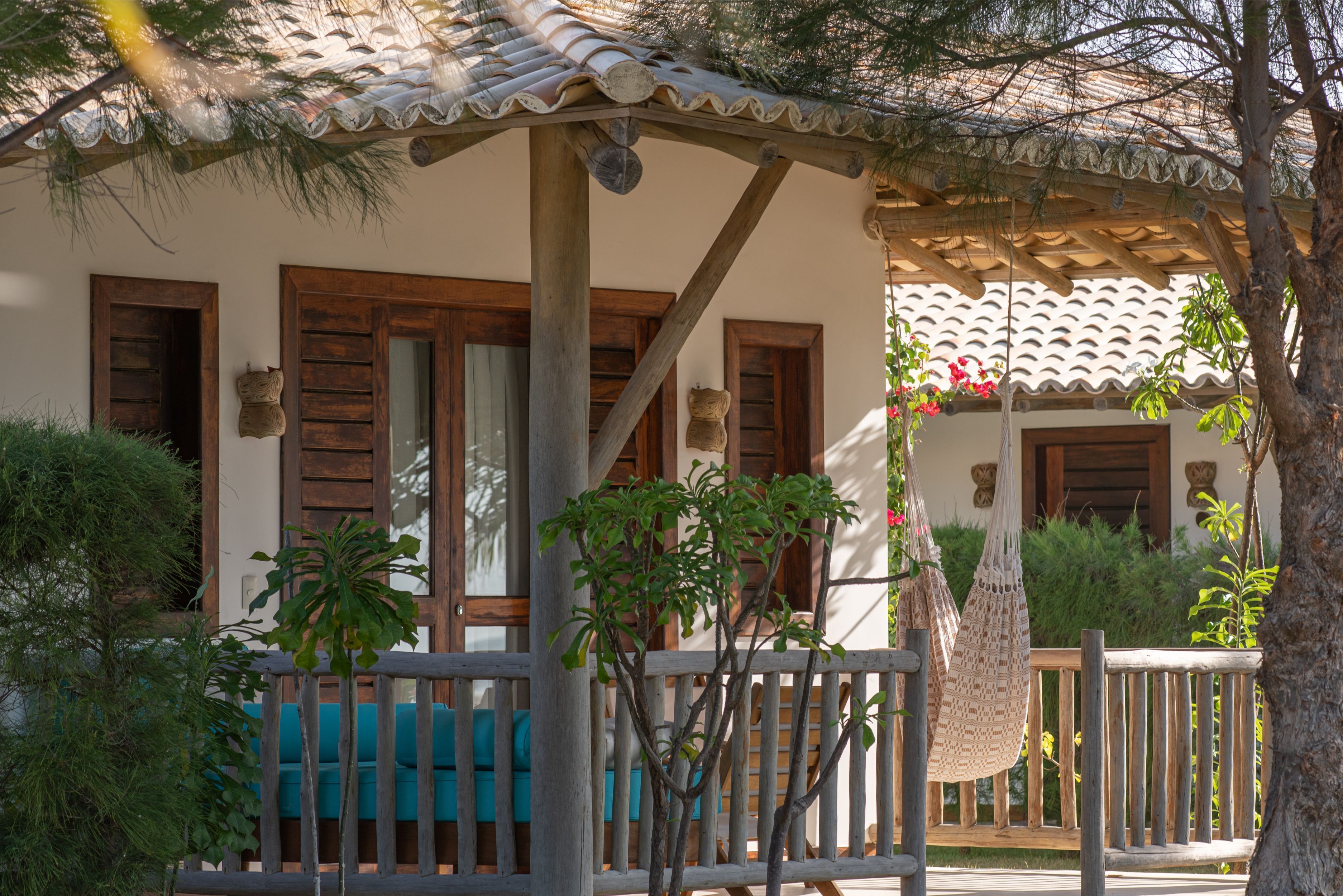 Un espace extérieur aménagé avec des bancs en bois et une pergola, le tout abrité.