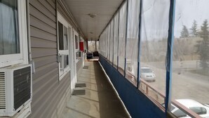Un couloir donnant sur une rue et sur des voitures garées à l’extérieur.