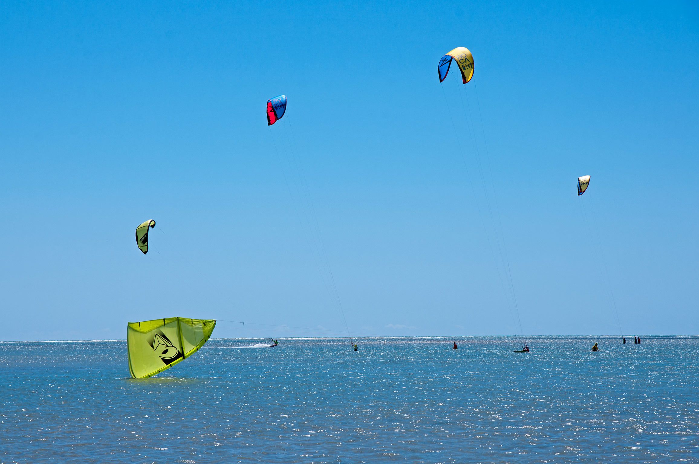 Un ciel d’un bleu limpide, parsemé de cerfs-volants qui volent au-dessus d’une mer calme.