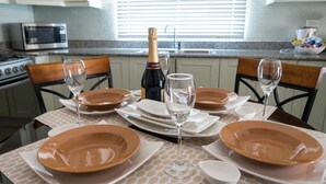 A dining table set with plates, glasses, and a bottle of champagne. - The Country Club Villa I (Kingston)