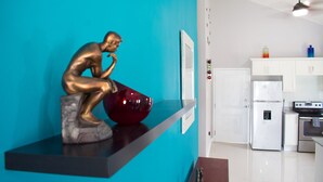 A kitchen with a white refrigerator, oven, and a teal wall. - The Country Club Villa I (Kingston)
