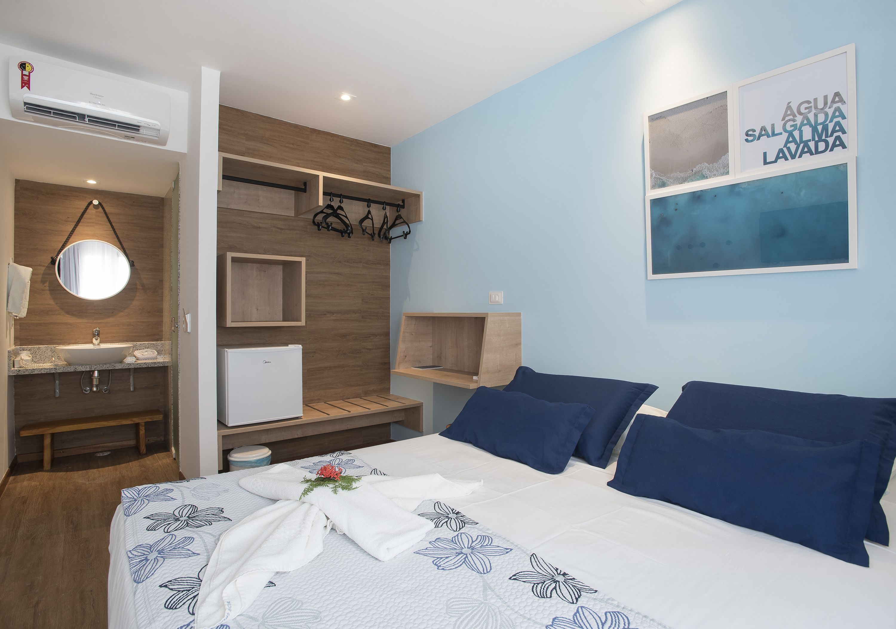 Una habitación de hotel moderna con una cama, un baño y un aire acondicionado de pared.
