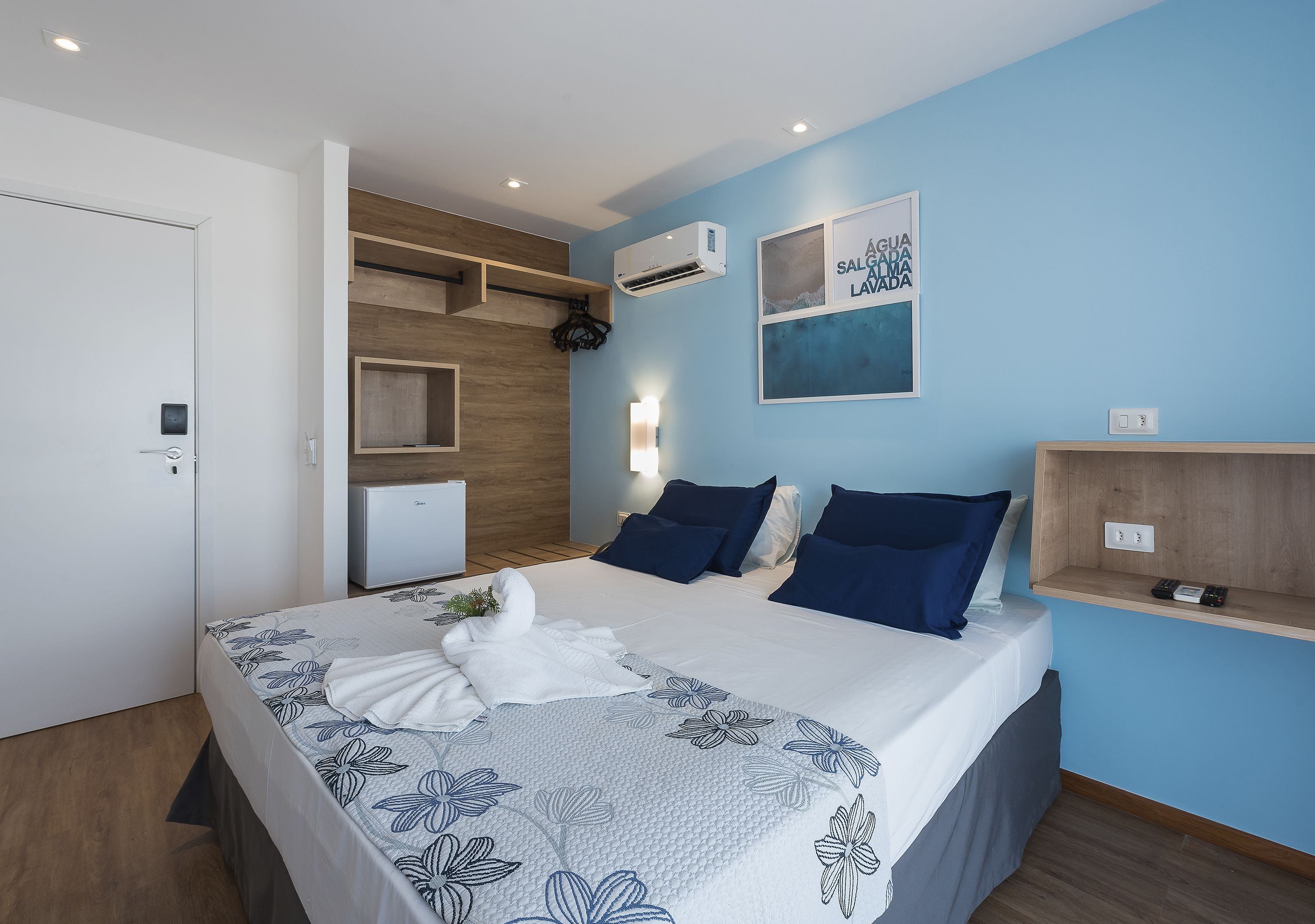Ein modernes Schlafzimmer mit einem Bett, blauen Wänden und einem Holzregal.