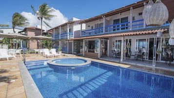 Een buitenzwembad en ligstoelen