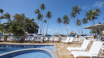 Una piscina al aire libre, sillones reclinables de piscina