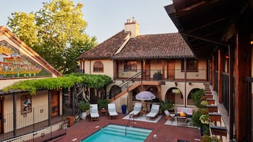Una piscina al aire libre, sombrillas, sillones reclinables de piscina