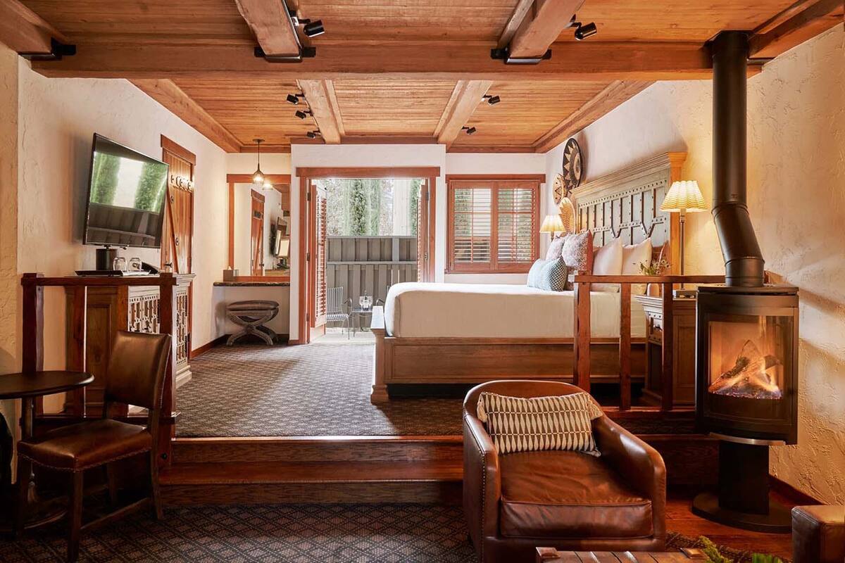 A cozy room with a bed, a television, a fireplace, and a dining area.