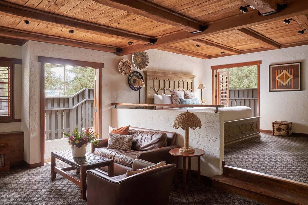 A cozy room with a wooden ceiling, a sofa, a small table, and a decorative lamp.