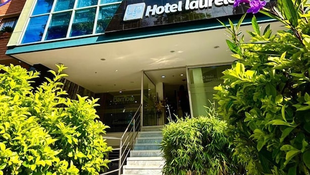 Moderni hotellirakennus, jossa on lasijulkisivu, kyltti, jossa lukee ”Hotel Laurele Plaza”, ja selvästi näkyvä sisäänkäynti, johon johtaa porras.