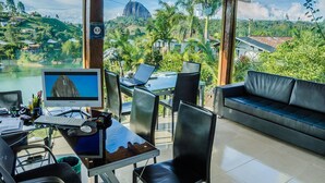 A modern room with a large window offering a scenic view of a mountain and lush greenery. - Hotel Santa Maria de las Aguas Peñol (El Peñol)