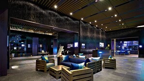 A spacious lobby with modern seating, a reception area, and a view of the cityscape.