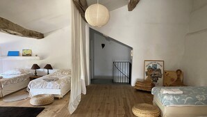 A bedroom with two beds, a wooden floor, a hanging light, and a staircase leading to another room. - 17th century character house in village center with swimming pool (Saint-Laurent-D'aigouze)