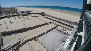 A beach view from a balcony with a wooden deck and a view of the beach and ocean. - Magnificent ocean view studio (Soorts-Hossegor)