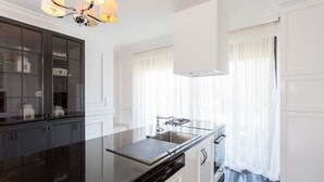 A modern kitchen with a black countertop, white cabinetry, and a stainless steel sink. - Mountain maissonette in Athens with breathtaking views.  (Athens)