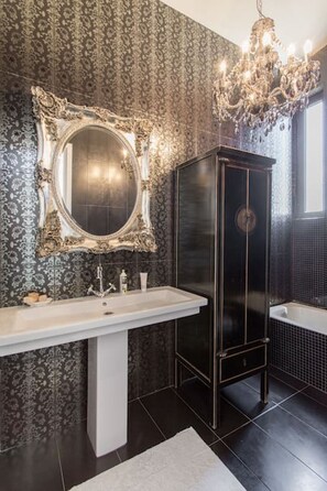 Een bad/douchecombinatie, een haardroger, handdoeken, zeep