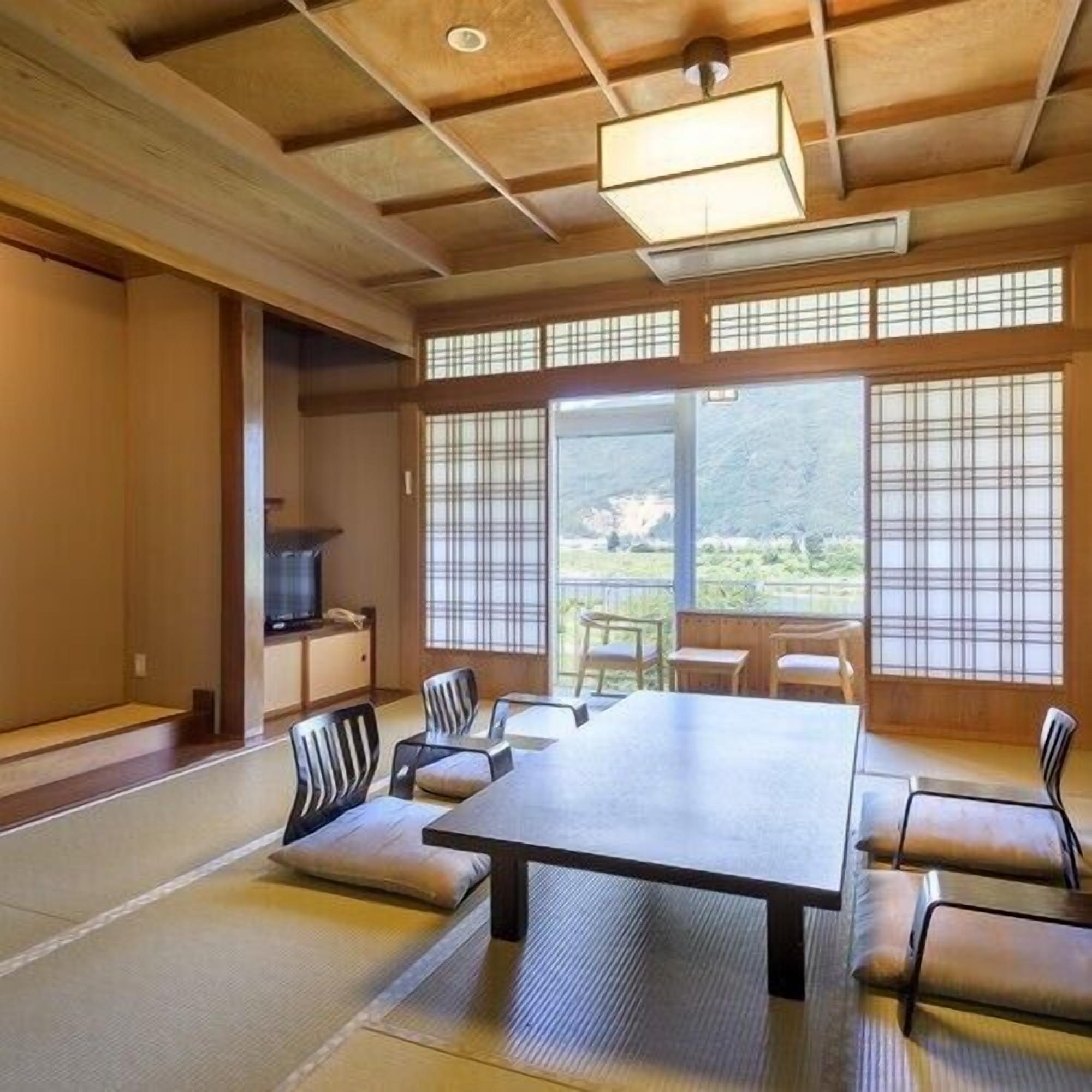 A traditional Japanese-style room with tatami flooring, a low table, and shoji screens.