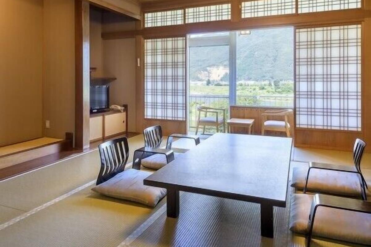 A traditional Japanese-style room with tatami flooring, a low table, and shoji screens.