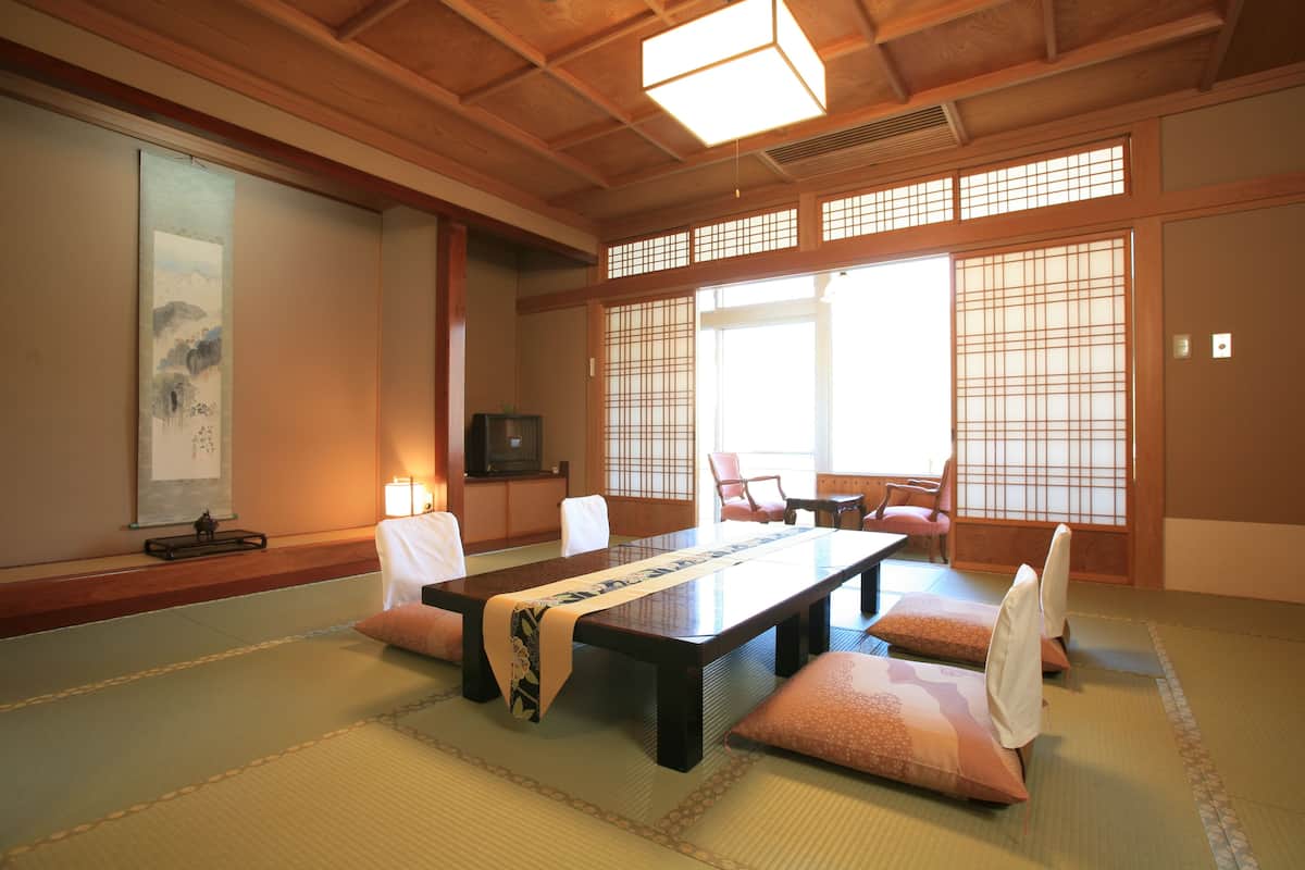 A traditional Japanese-style room with tatami flooring, a low table, and shoji screens.