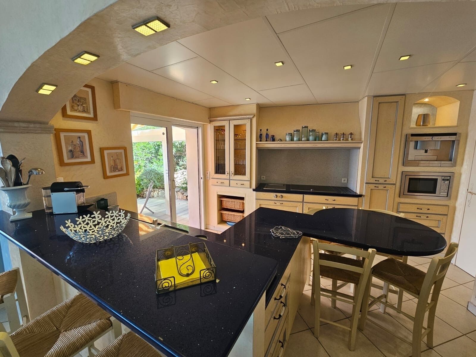 A kitchen with a central island, built-in microwave, and sliding glass doors leading to a patio.