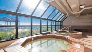 A rooftop pool with a view of a bridge and greenery.