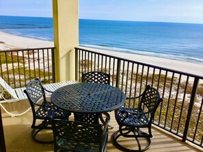 A balcony with a round table and four chairs, overlooking a beach and the ocean. - Garage Parking included! BEACHFRONT CONDO with A GULF Front MASTER! AWESOME VIEW (Orange Beach)