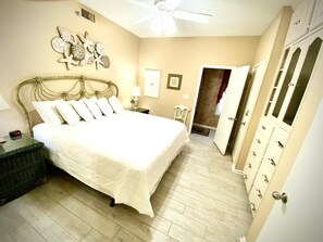 A bedroom with a bed, a nightstand, a ceiling fan, a wall decoration, a door, and a wardrobe. - Garage Parking included! BEACHFRONT CONDO with A GULF Front MASTER! AWESOME VIEW (Orange Beach)