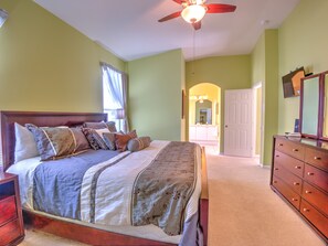 Une chambre à coucher avec un lit, une commode et un ventilateur de plafond.