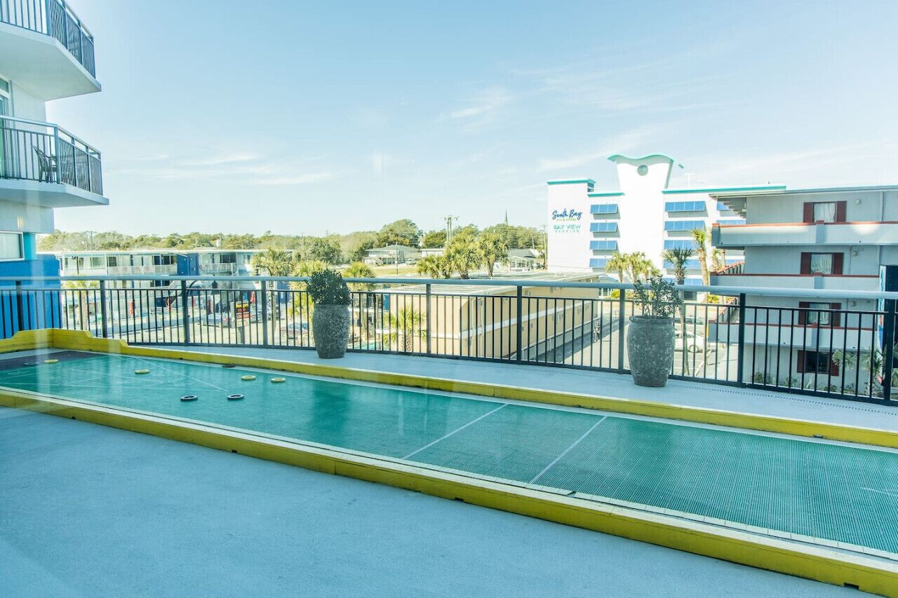 Uma área de piscina com vista desobstruída dos edifícios ao redor, incluindo um hotel chamado "South Bay".