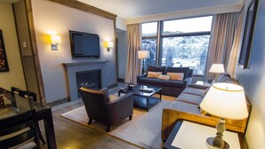A modern living room with a fireplace, sofa, and dining area. - Luxury Westin Resort and Spa Ski-in/out, sleeps 8, Mountain Views (Avon)