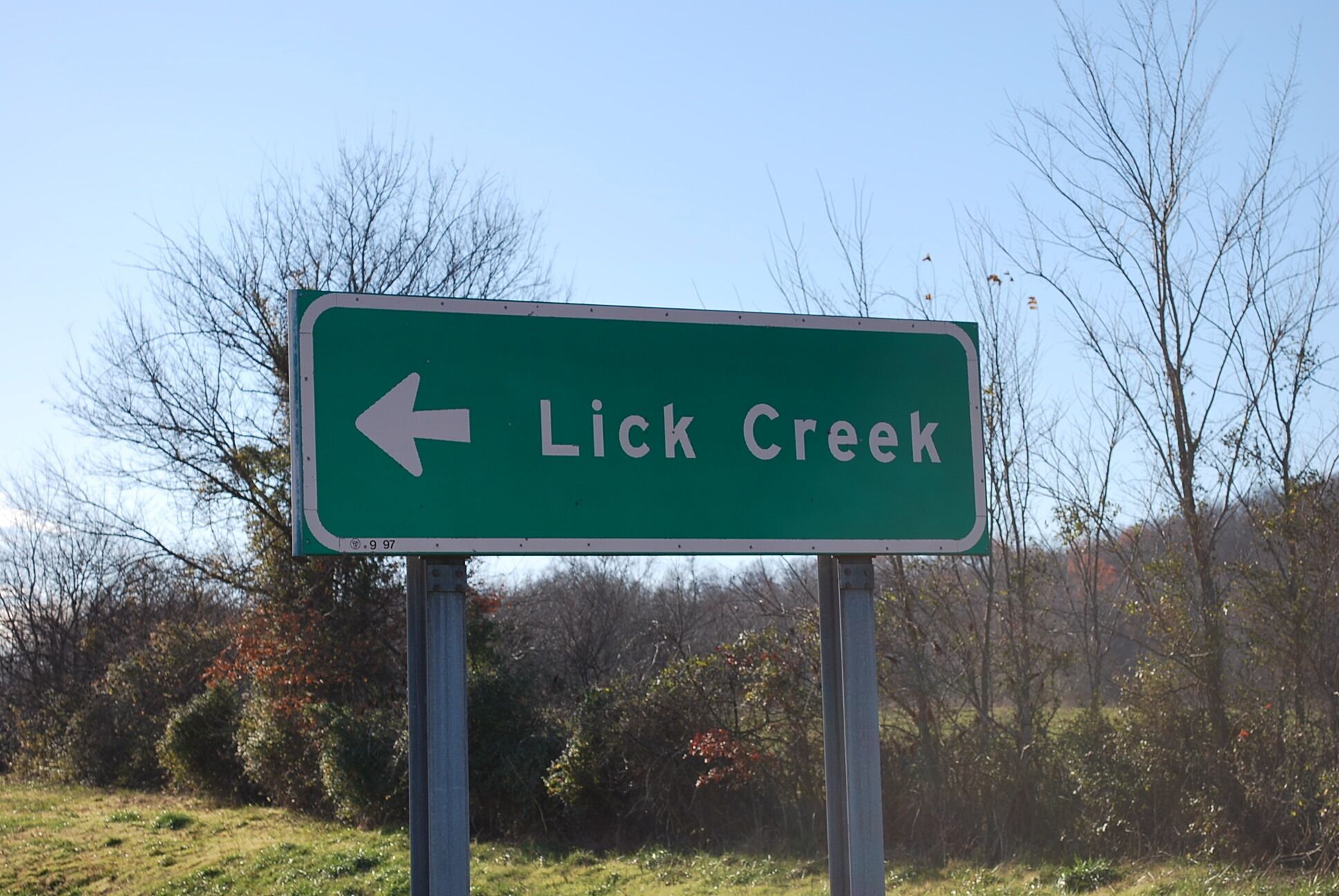 A directional sign for Lick Creek.