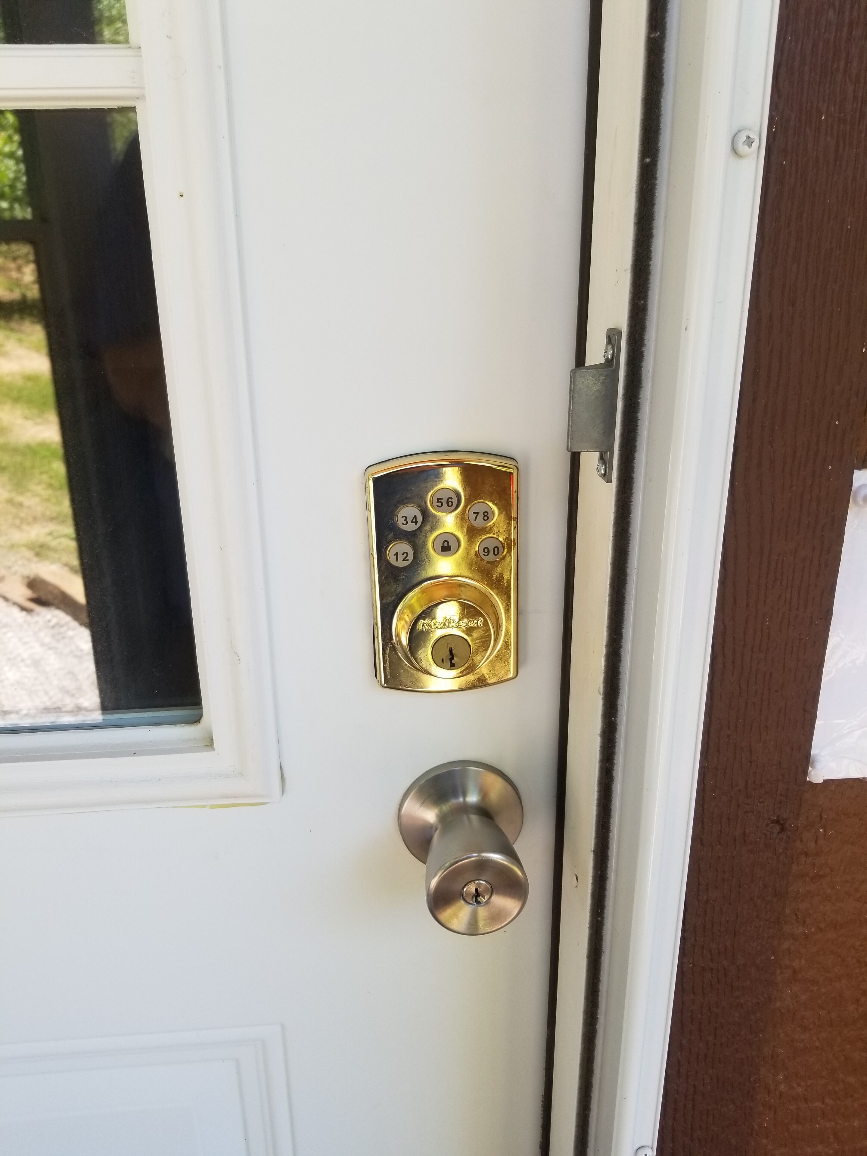 A door with a keypad lock and a keyhole.