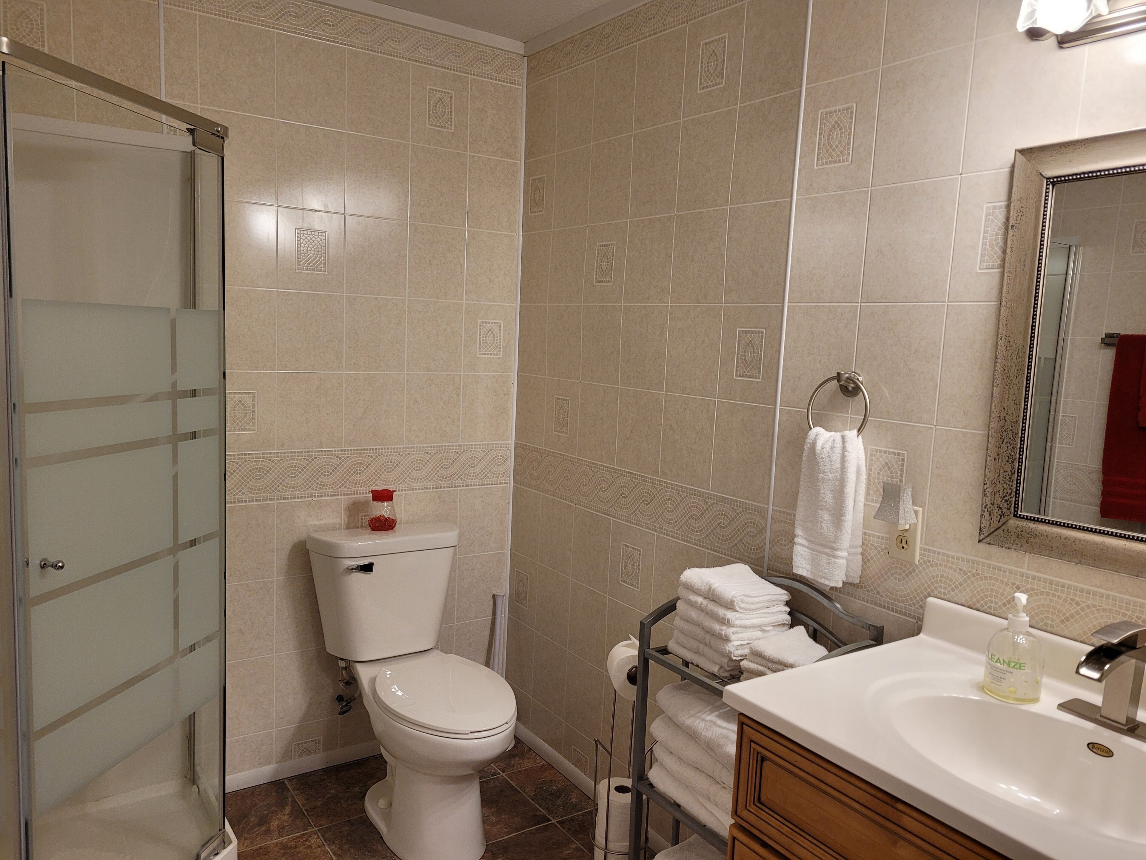 Une salle de bain avec des toilettes, un lavabo et un miroir.