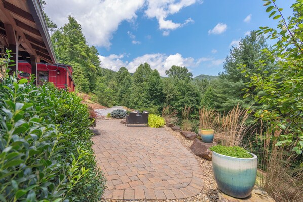 A paved pathway leading to a red building with outdoor seating.