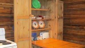A compact kitchen with wooden cabinets, a stove, and a table. - The Benjamen - Newly Remodeled Great Views (Cody)